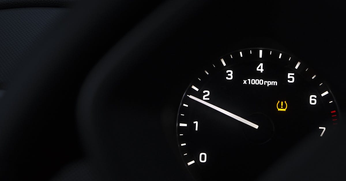 A detailed view of a car tachometer showing RPM with tire pressure warning.