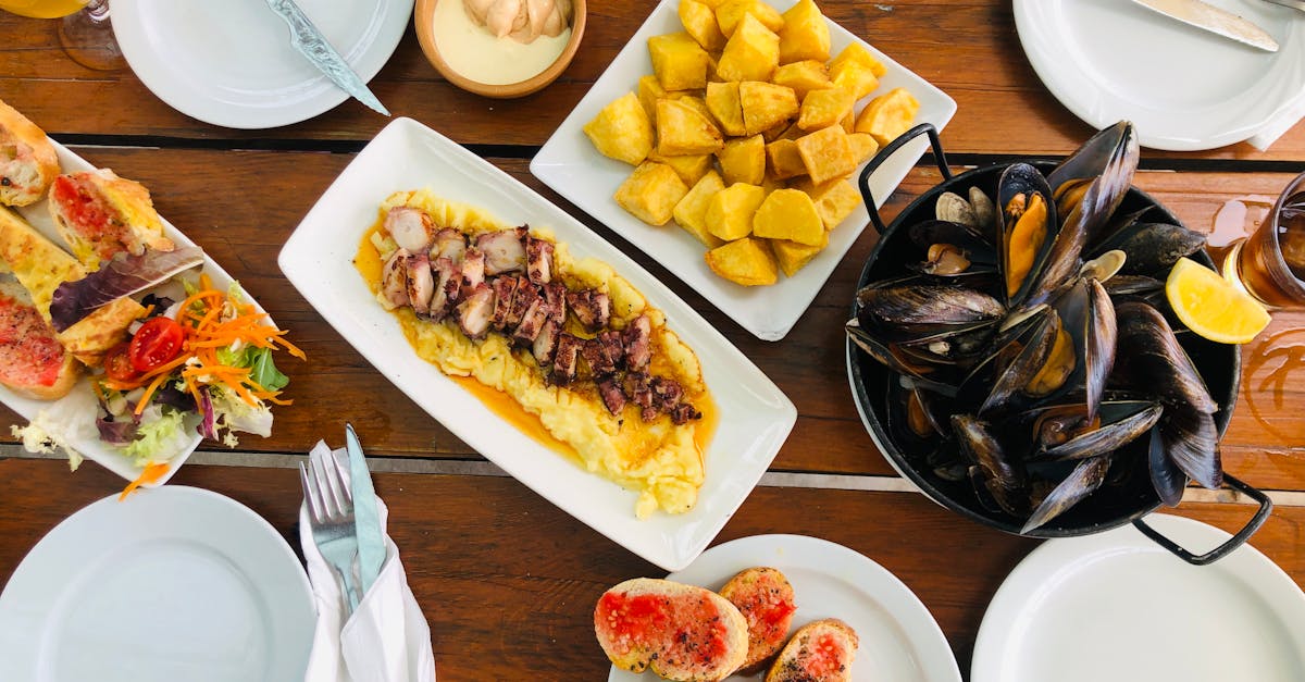 An appetizing display of Mediterranean seafood dishes at a restaurant table, featuring clams and regional delicacies.
