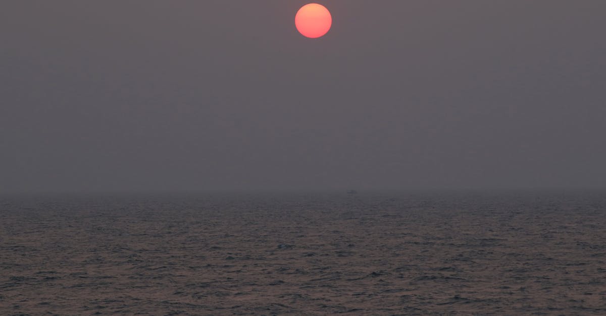 Serene sunset casting a warm glow over the vast ocean horizon, conveying peace and calm.