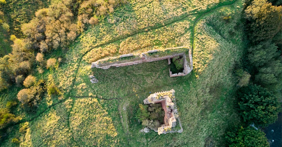 Drone shot of ancient ruins surrounded by lush greenery in Scotland.
