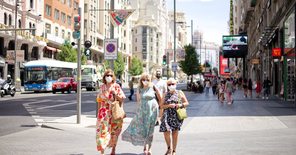 A group wearing masks walks down a busy street in Madrid, capturing urban life during the pandemic.