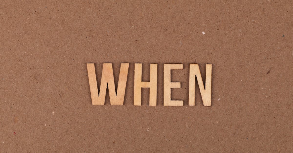Wooden letters forming the word 'When' on a plain cardboard background.