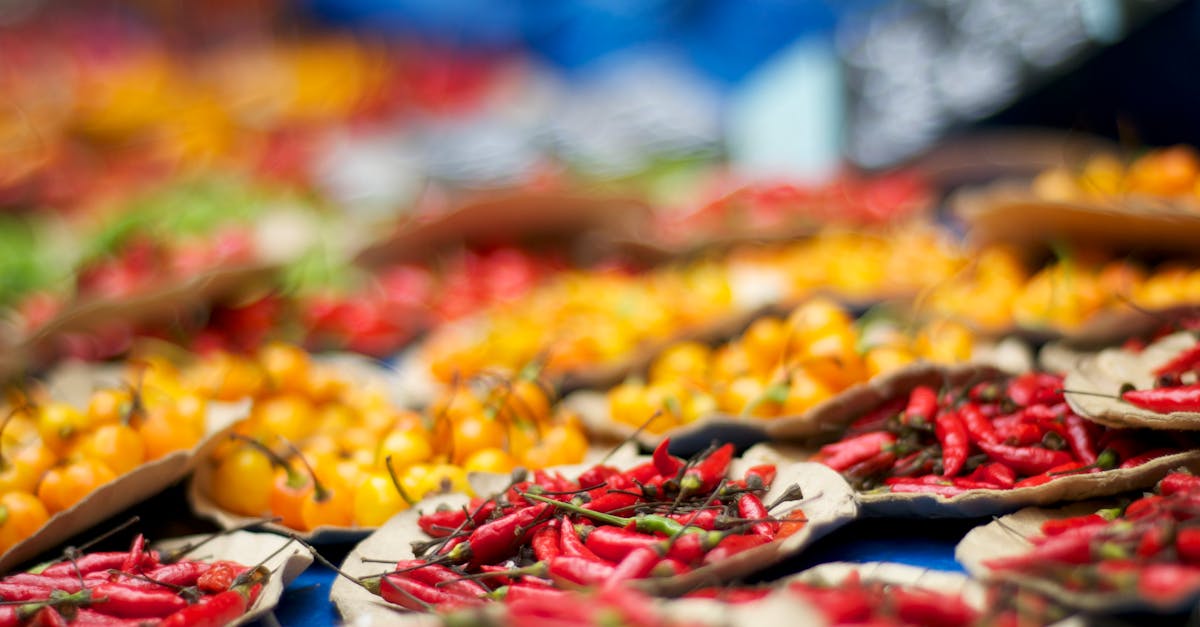 Colorful display of red and yellow peppers at an outdoor market, showcasing fresh organic produce.
