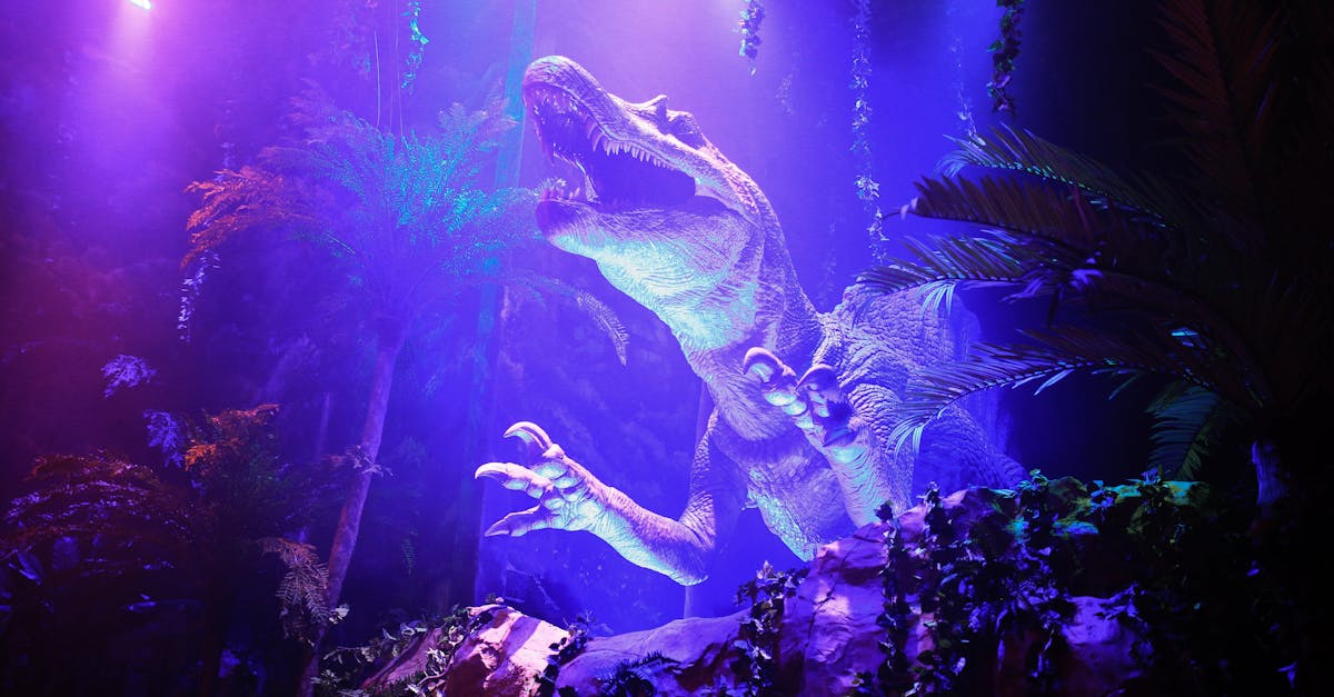 A vibrant and illuminated dinosaur exhibit in a themed park jungle setting.