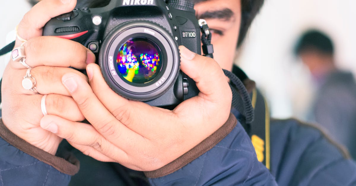 A person holding a Nikon DSLR camera capturing a vibrant image reflection.