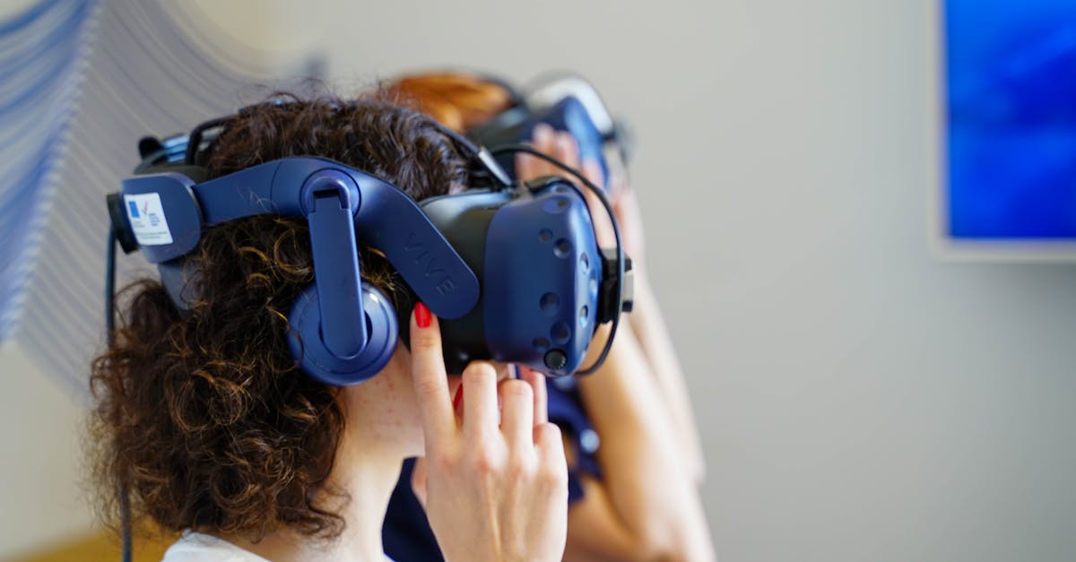 Two women using VR headsets, fully immersed in virtual reality technology indoors.