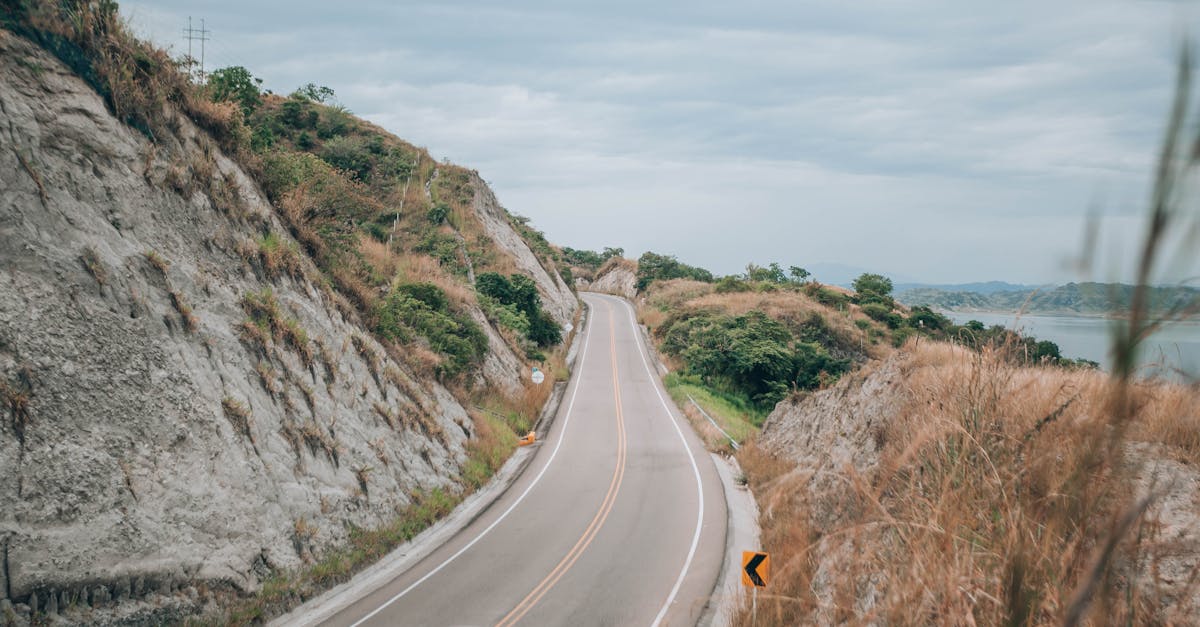 Winding road through picturesque hills under an overcast sky, perfect for travel and exploration.