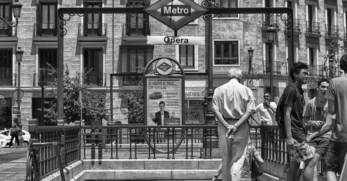Black and white photo of Opera Metro station entrance in Madrid, bustling with people.