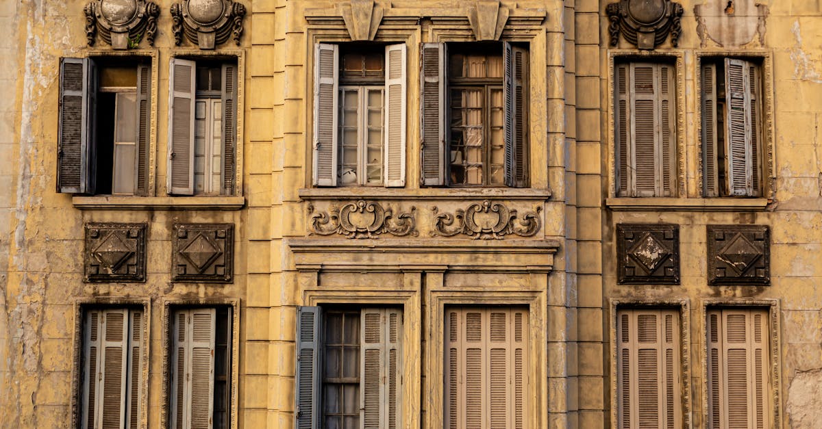 Close-up of a neoclassical Parisian building facade showcasing elegant, ornate window designs.