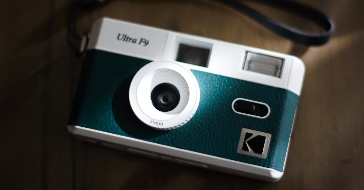 Close-up of a retro Ultra F9 camera with a leather strap on a wooden table.