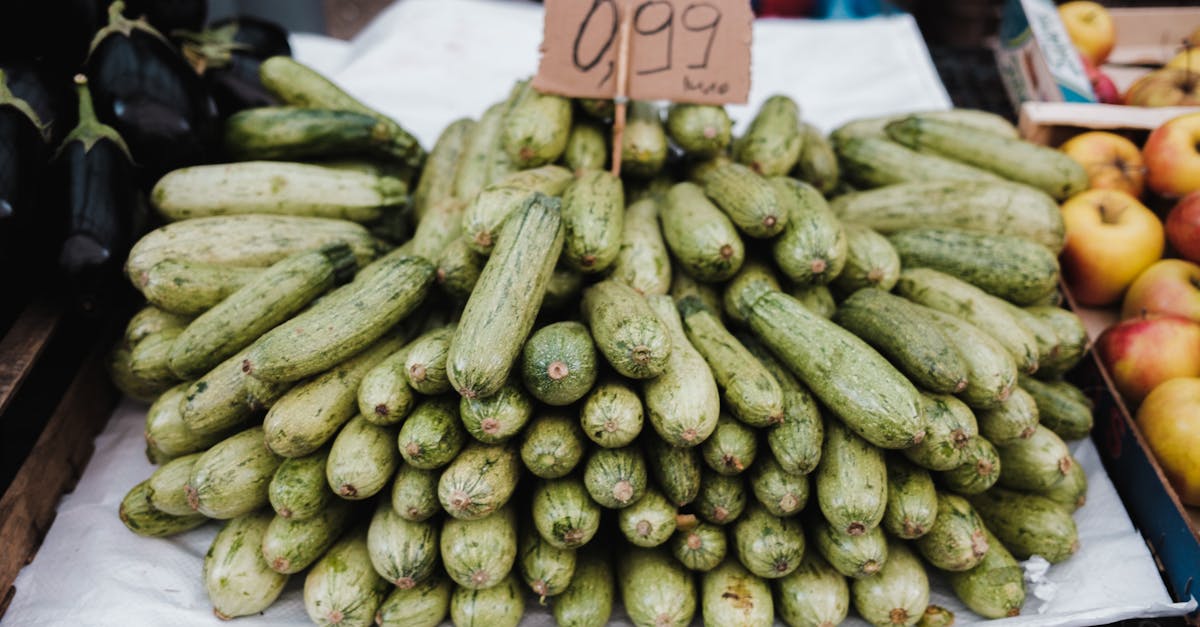 Pile of fresh zucchini on display with price at a local farmers market.