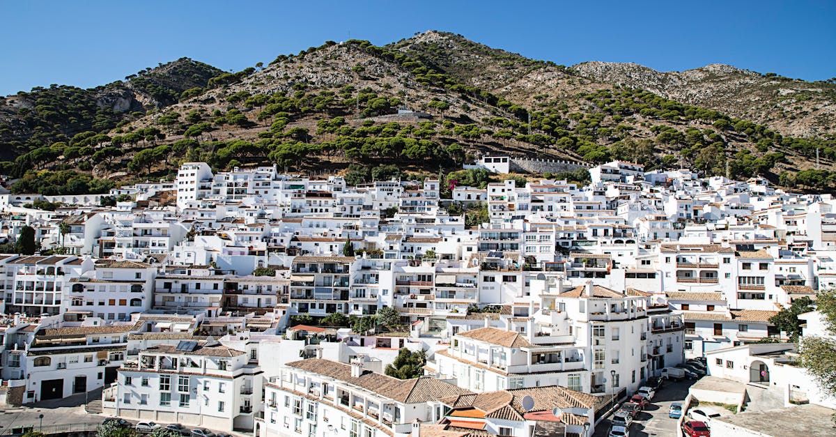 Charming view of a whitewashed Spanish town nestled in the hills during a sunny day.
