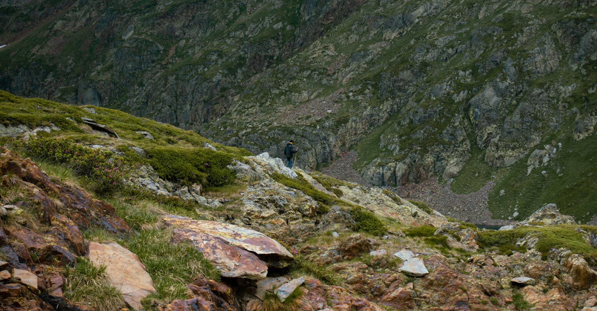 A lone hiker traverses rugged mountain landscape offering adventure and solitude.