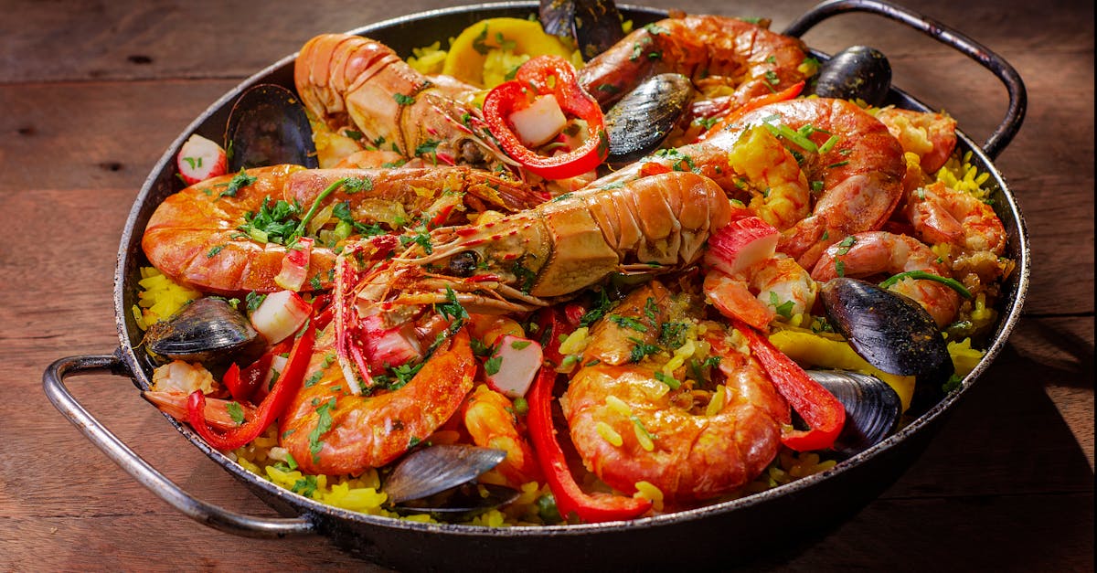 A vibrant and flavorful seafood paella served in a pan with mussels and shrimp.