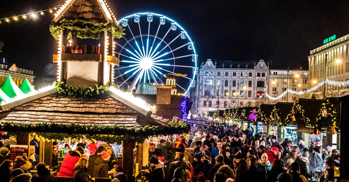 Crowded night market with neon lights and ferris wheel creating a festive atmosphere.