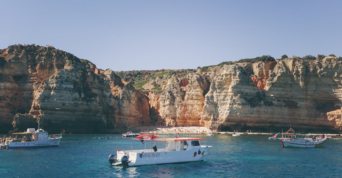 Explore the stunning rocky cliffs and clear blue waters on a boat tour under the summer sun.
