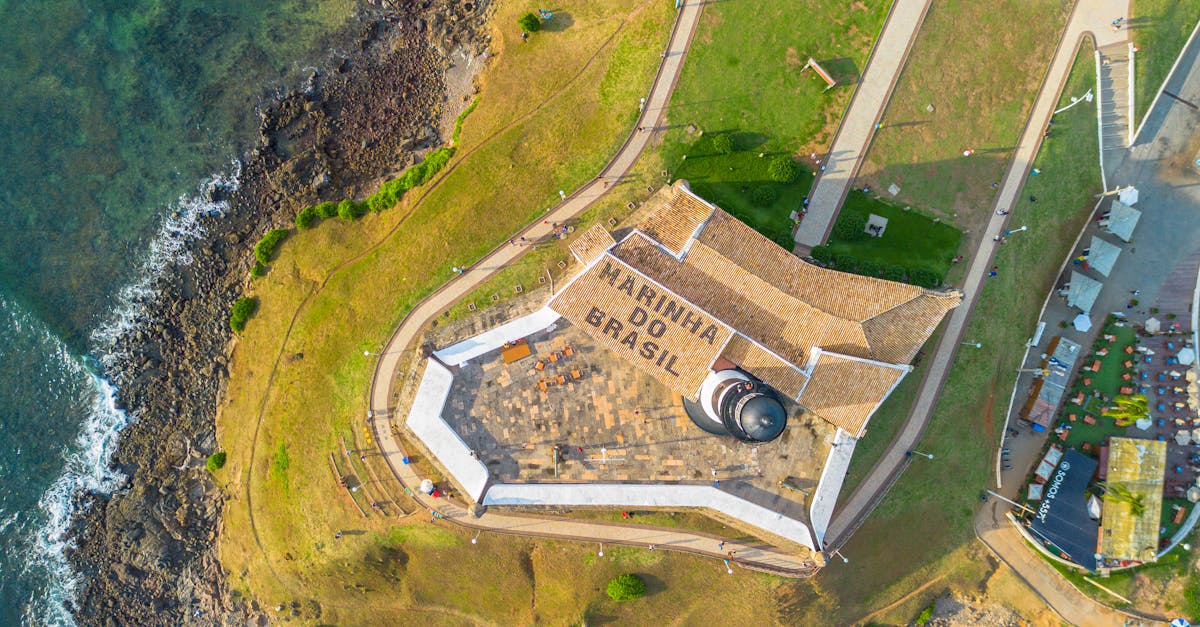 A stunning aerial view of the historic Barra Lighthouse on the coast of Salvador, Brazil.