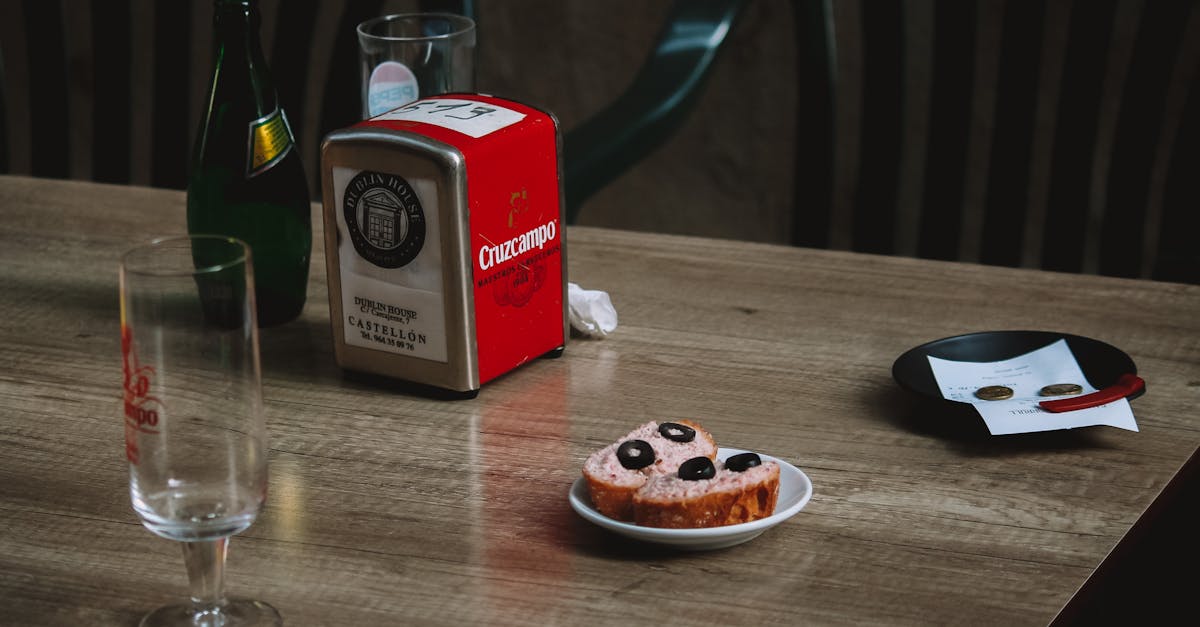 Cozy cafe scene featuring tapas, glasses, and a bottle on a wooden table for a casual dining atmosphere.