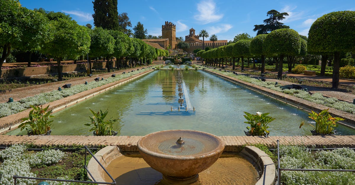Explore the tranquil gardens of Alcázar de los Reyes Cristianos in Córdoba, Spain, with its historic architecture and lush greenery.