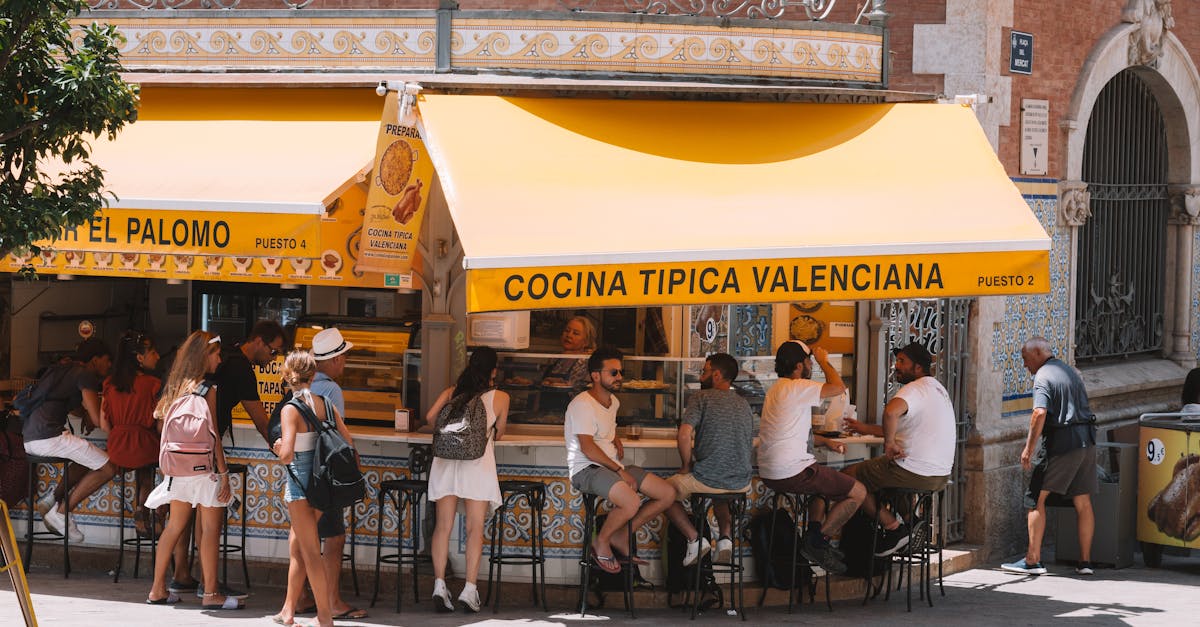 People enjoying local cuisine at a bustling Valencia street café.