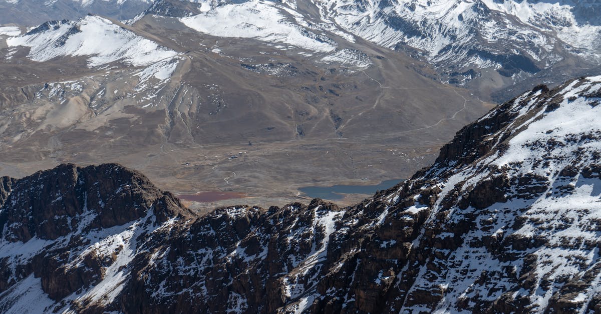 Aerial view of snow-covered mountains with rugged peaks and valleys.
