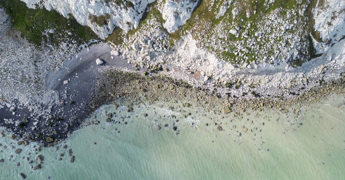 A stunning aerial view of Eastbourne's white cliffs and rocky shore in England.