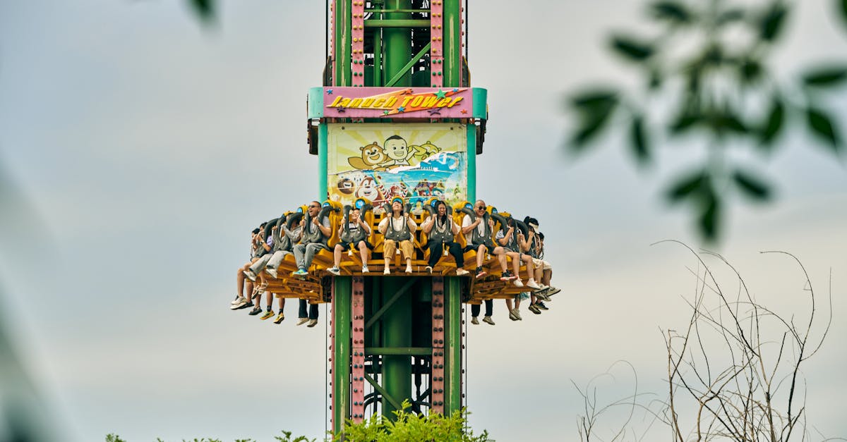 Thrilling drop tower ride with people enjoying an adrenaline rush in an amusement park setting.