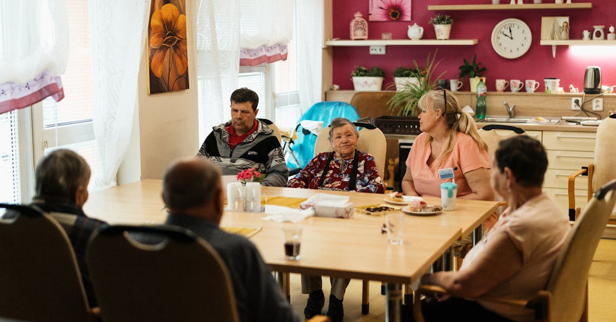 Seniors enjoying a meal in a nursing home dining room with caregivers in Karviná, Czechia.