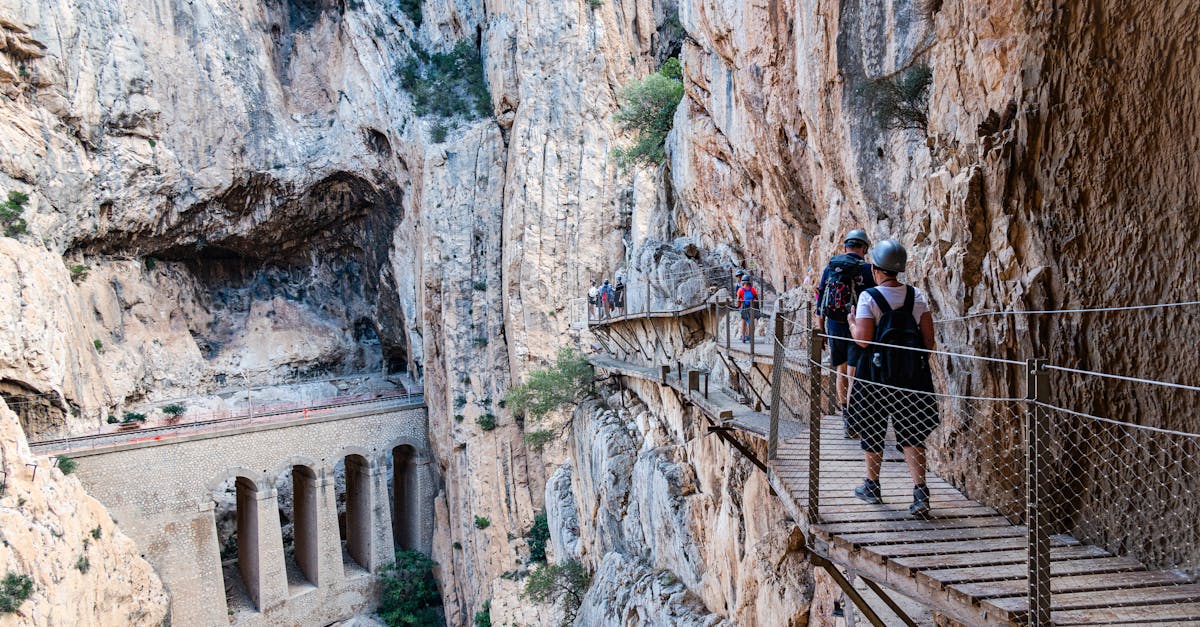 Adventurers on the narrow Caminito del Rey walkway in Spain's scenic El Chorro gorge.