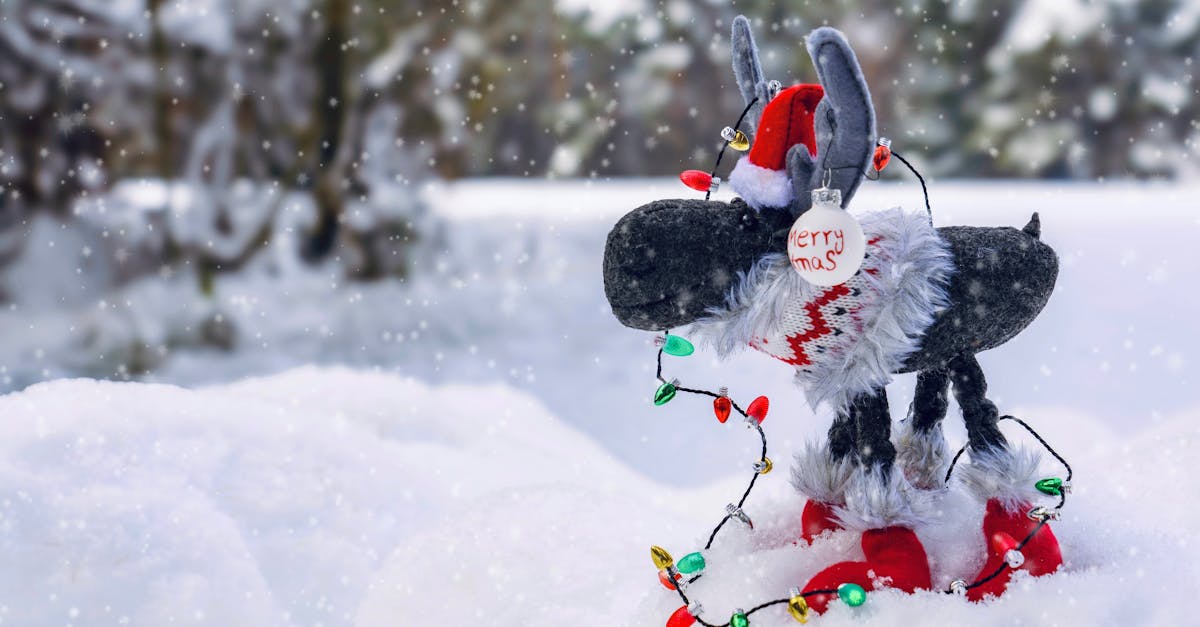 Plush reindeer toy adorned with holiday lights in a snowy winter scene.