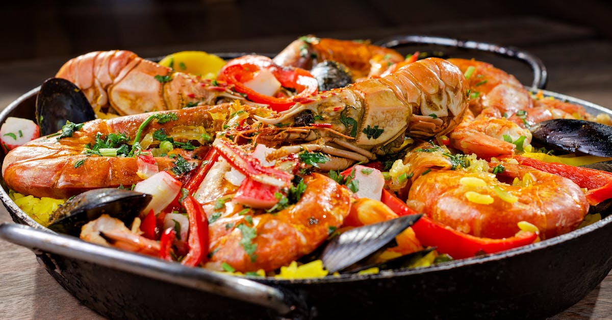 Close-up of a colorful seafood paella dish with prawns and mussels.