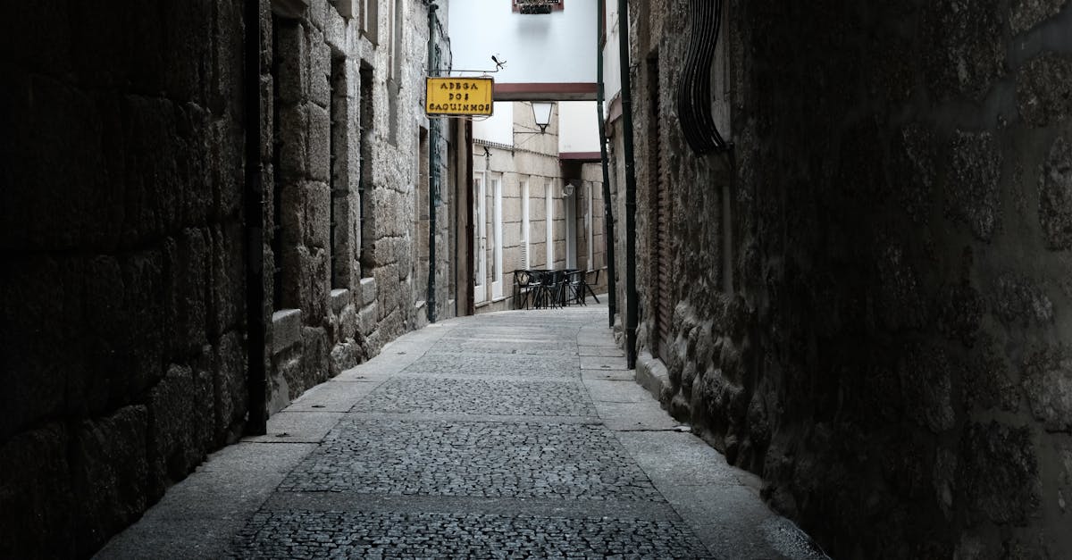 Captivating narrow alley with stone walls in Guimarães, Portugal, evoking a sense of history.