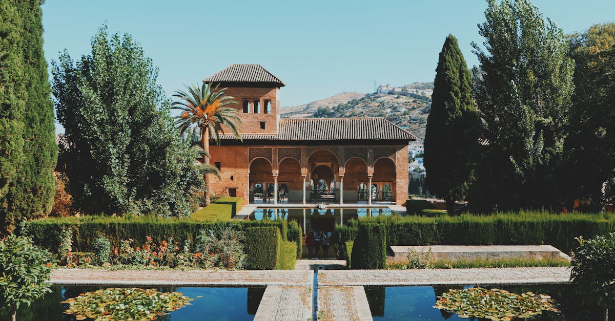 Beautiful view of El Partal in Alhambra, Granada, featuring lush gardens and reflective pools.