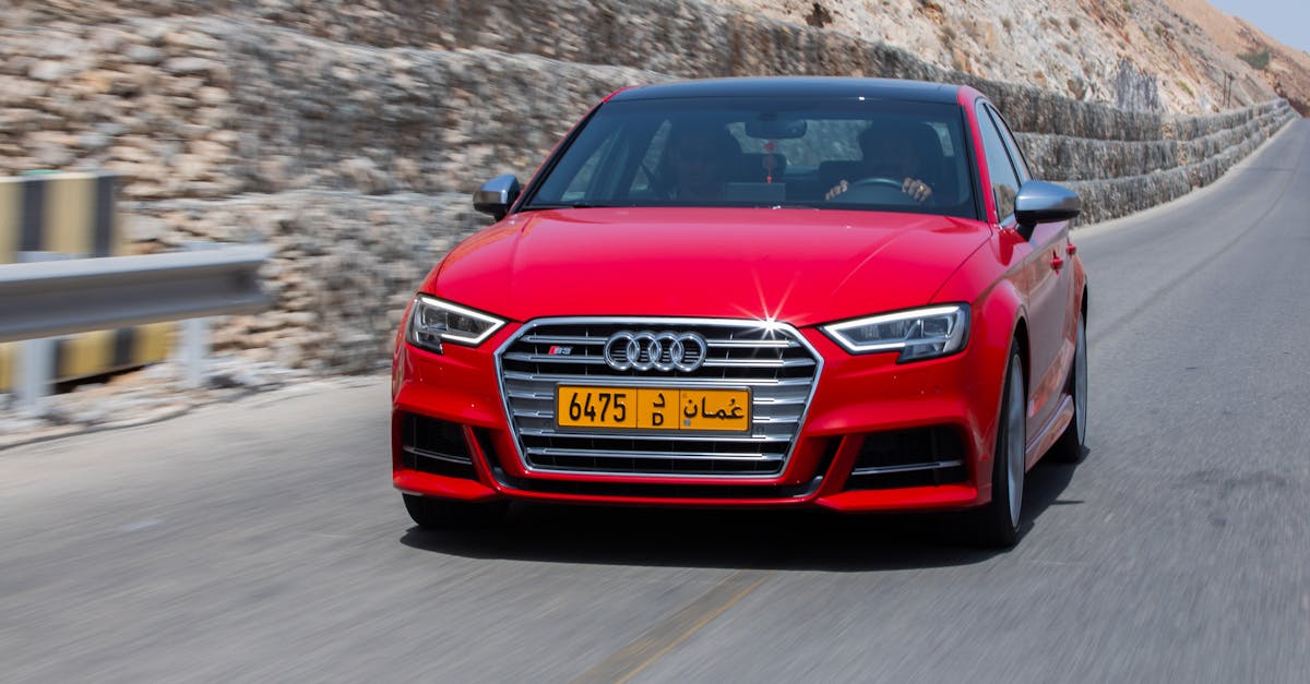 A dynamic shot of a red Audi S3 driving on a mountain road in Muscat, Oman.