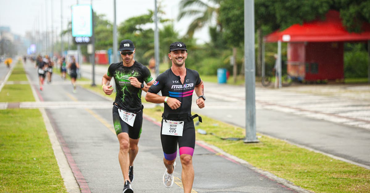 Two male athletes competing in a city marathon, running energetically on a pavement track.