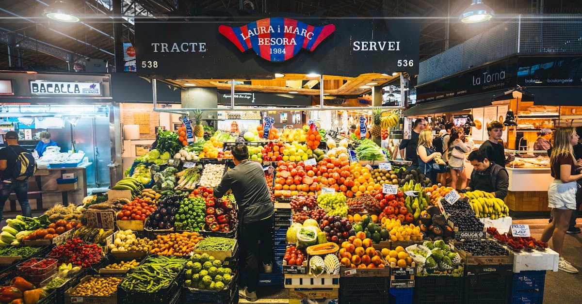 Colorful market stall displaying fresh fruits and vegetables in Barcelona's bustling market.