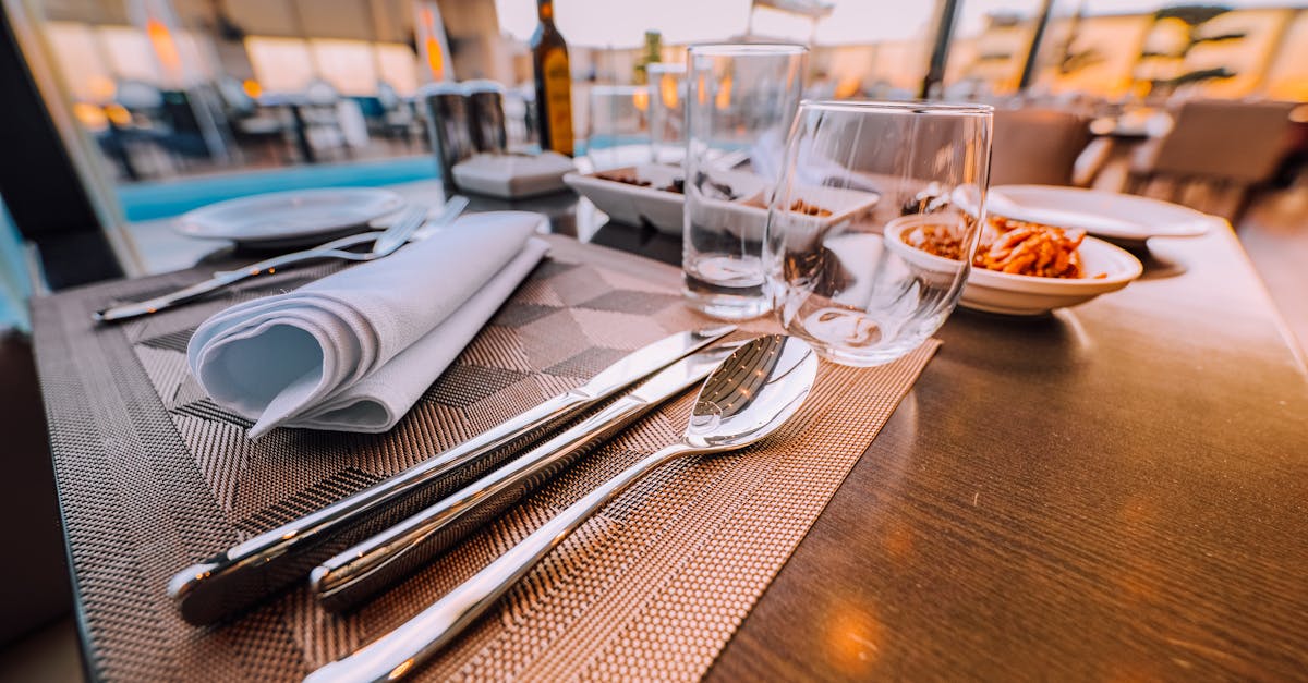 Close-up of an elegant table setting at a stylish outdoor restaurant with ambient lighting.