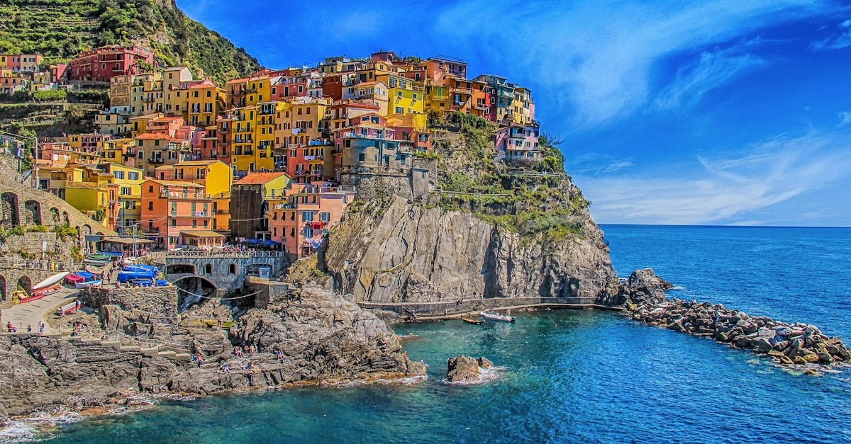 Vivid view of Manarola's colorful houses perched on cliffs, overlooking the blue sea.