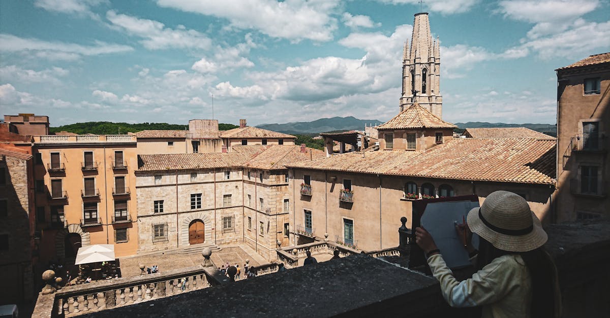 A scenic view of a Catalonia landmark with a person sketching outdoors.