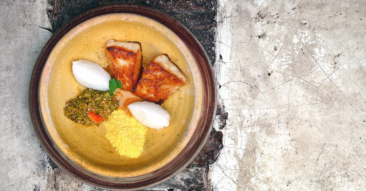 Top view of a traditional fish dish with rice and vegetables on a rustic plate, perfect for food photography.