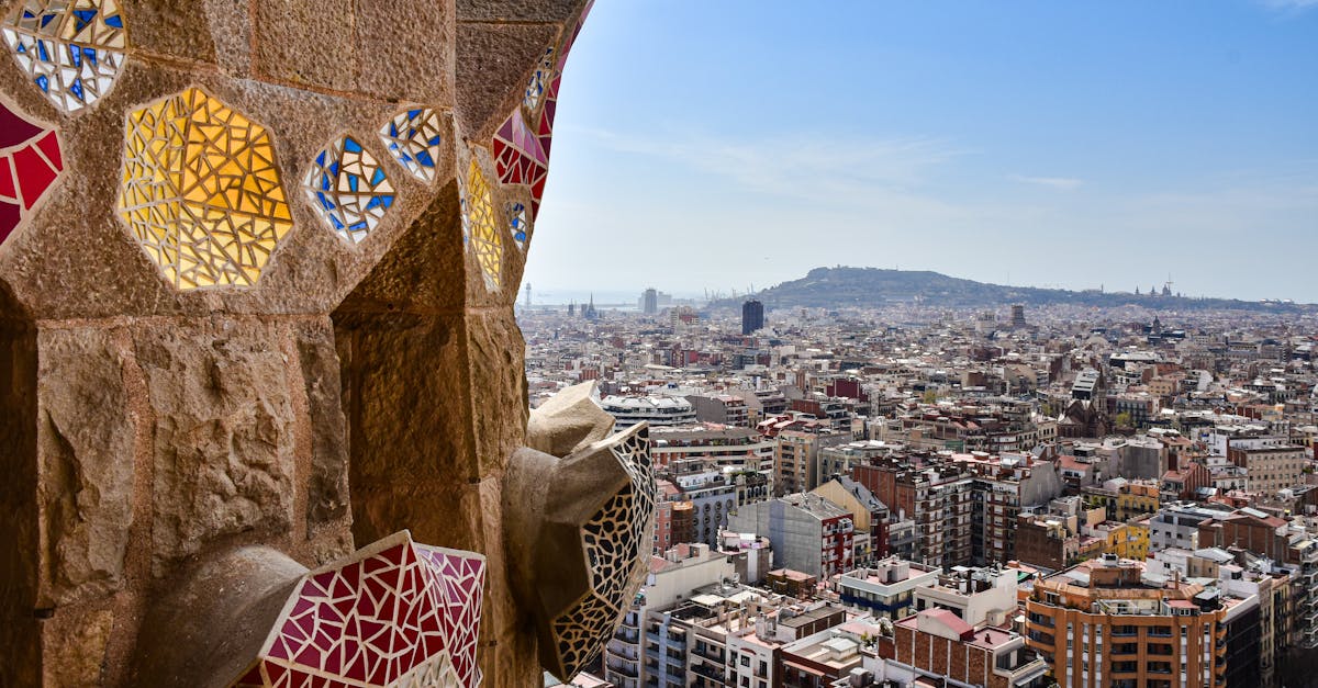 View from a mosaic tower overlooking the vibrant cityscape of Barcelona, capturing architectural beauty and urban life.