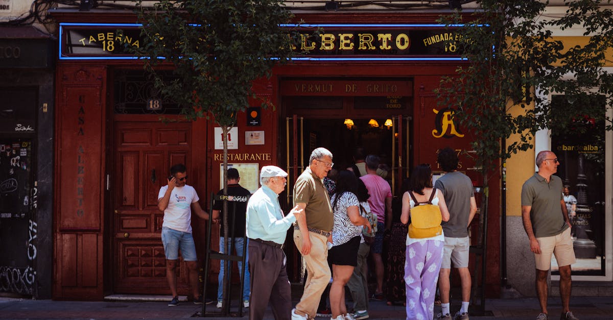 People gathering outside Taberna Alberto in Madrid, Spain, capturing local street life.