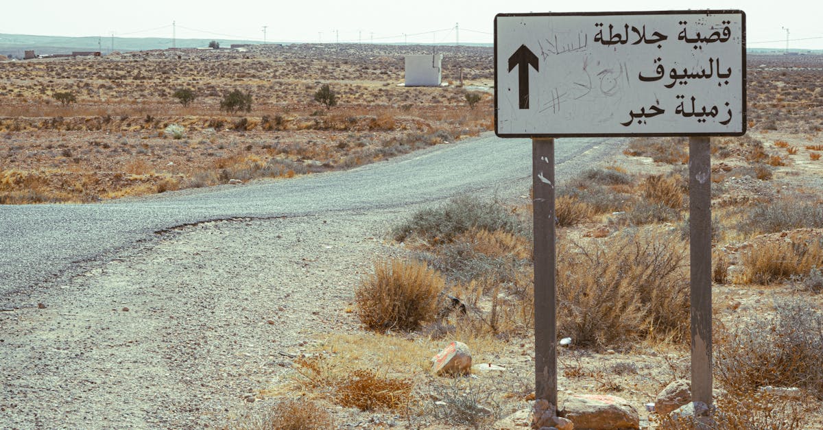 Directional sign on a desert road in Tataouine, Tunisia with Arabic text.