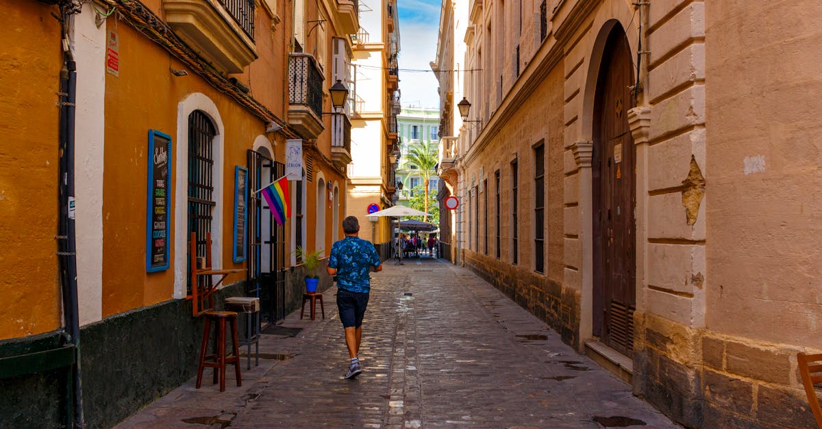A vibrant alleyway with colorful buildings and a lone pedestrian in a historic European city.