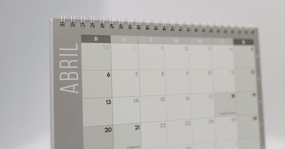 Close-up of a spiral-bound April desk calendar with a gray minimalistic design.