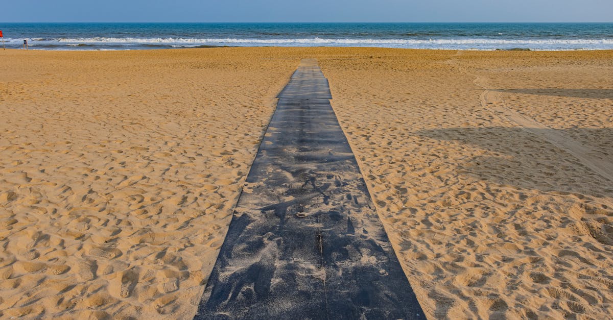 Tranquil view of the sandy Puri beach with a pathway leading to the blue ocean in Odisha, India.