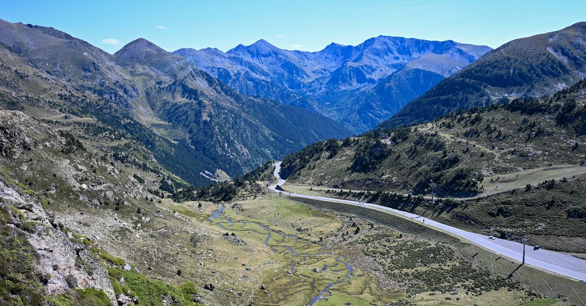 Aerial view of a winding road cutting through the lush Pyrenees mountains.