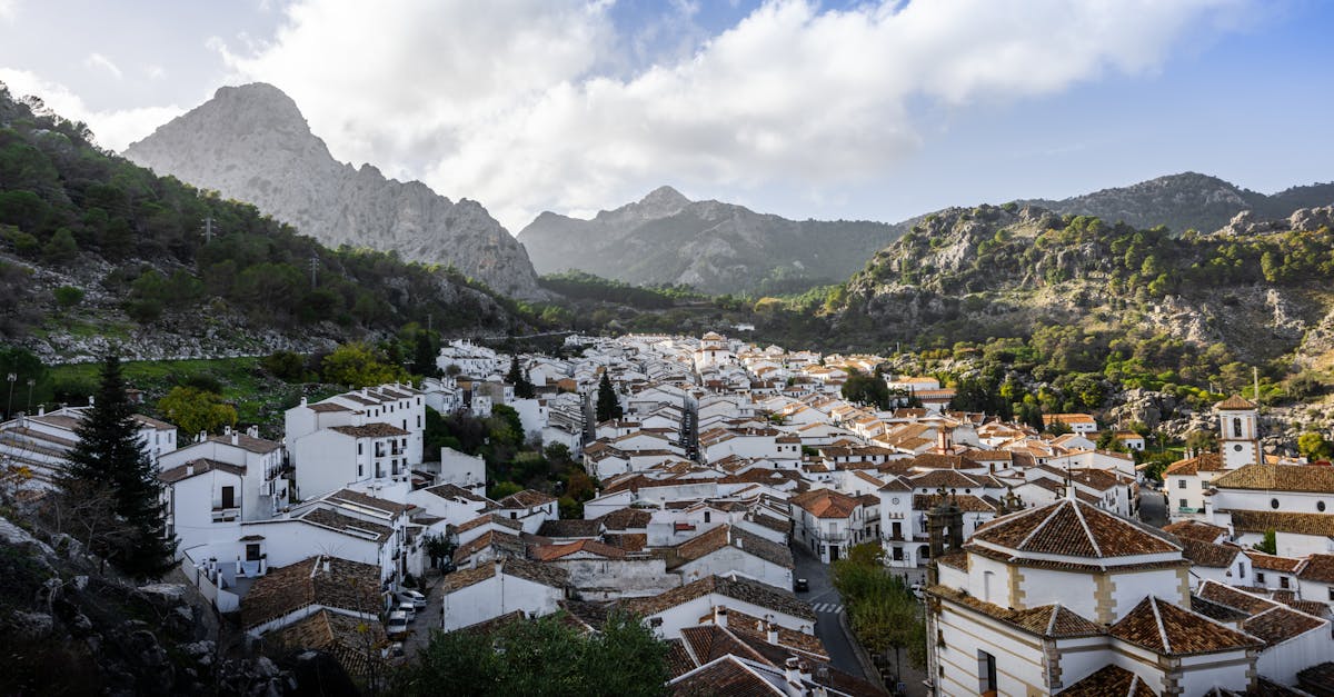 Charming white village surrounded by lush mountains in a picturesque Spanish landscape.
