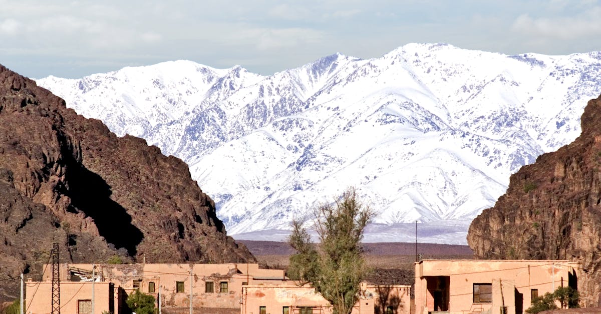 Village in Ouarzazate with snowy Atlas Mountains in the background.