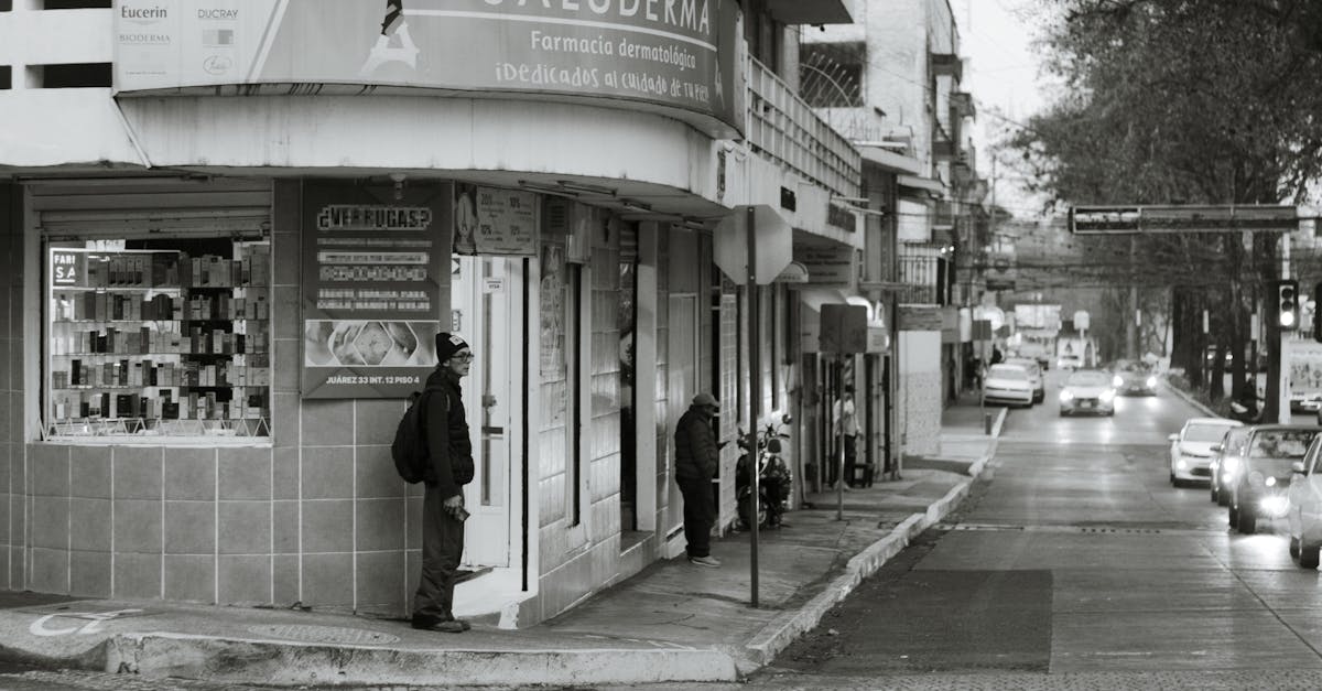Black and white street scene in Xalapa, Mexico, with pedestrians and vehicles.